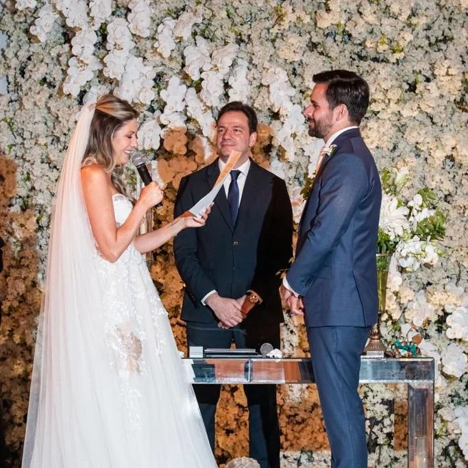 Gabriel celebrando um casamento sob um arco de flores